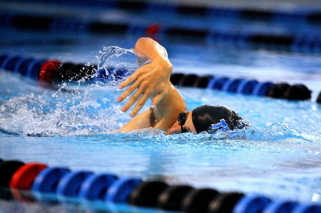 a professional woman swimmer, swimming in a pool - this picture is used in article about omega 3 benefits for swimmers