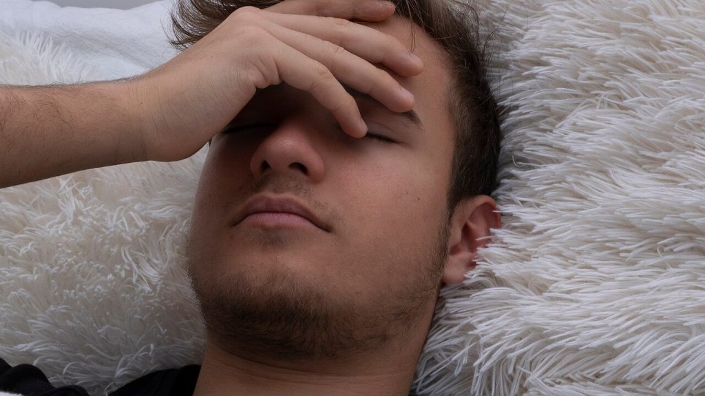boy laying down, seemingly sick - picture is used in article on omega-3 benefits for low blood pressure