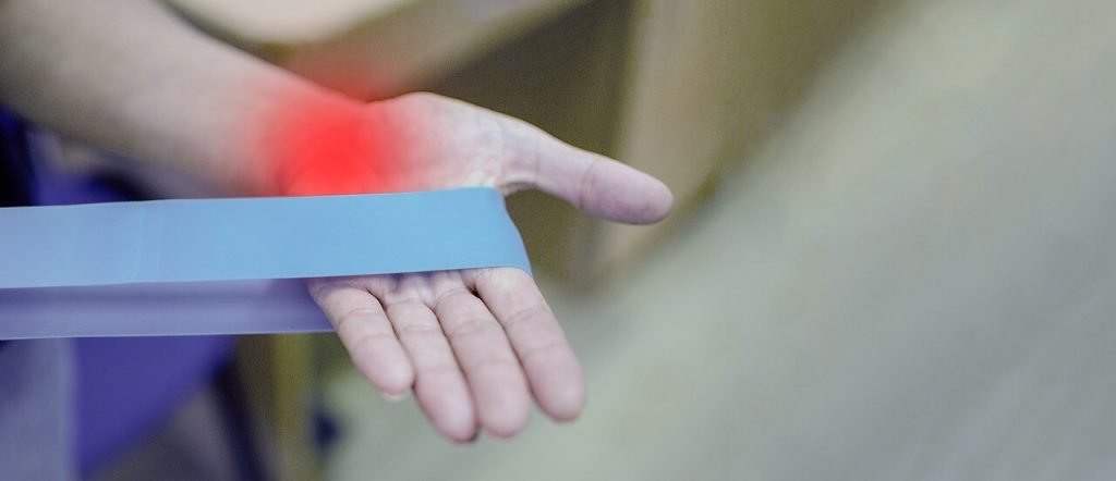 a hand holding a elastic medical blue band - this picture is used in article about omega 3 benefits for arthritis