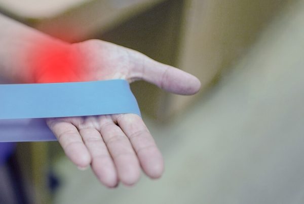 a hand holding a elastic medical blue band - this picture is used in article about omega 3 benefits for arthritis