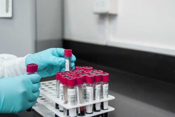 hand picking bottles in a lab - used in article on EU GMP Compliance