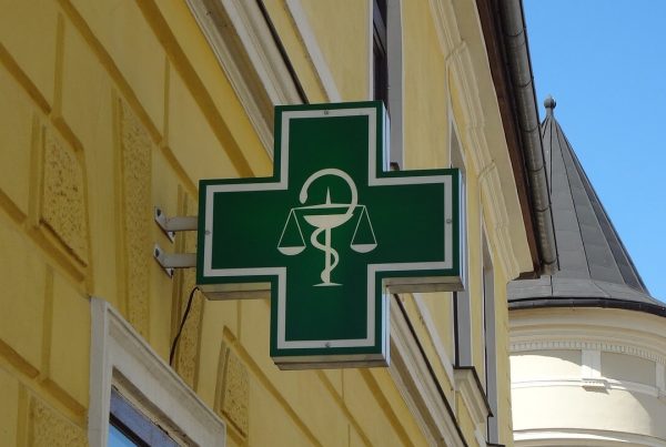 pharmacy sign on a yellow building - used in article on medicine supply bottlenecks