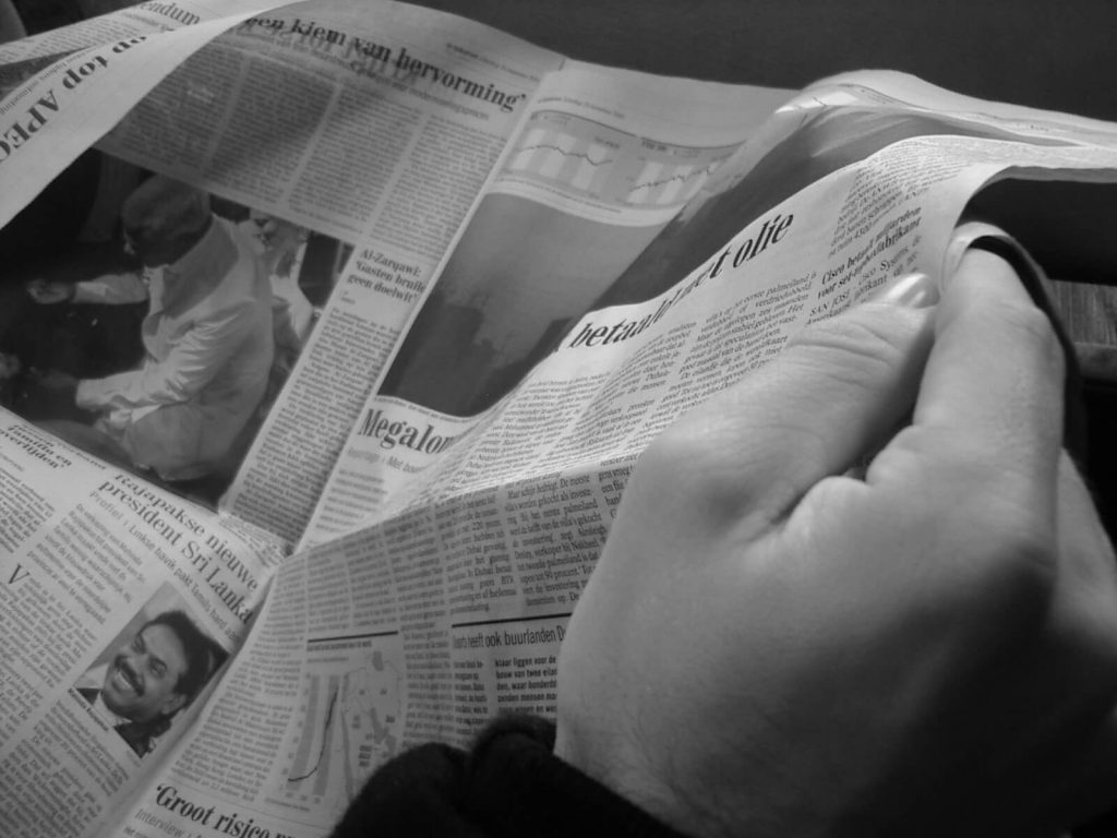 black and white picture of male hands holding a newspaper - anitiotic crisis Germany news