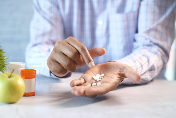 a man holding medicine in his hand - used in article on antibiotic supply bottlenecks