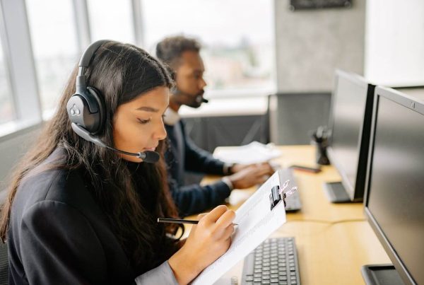 Woman With Headset Holding A Clipboard and Taking Notes - used in article on Complaint Management